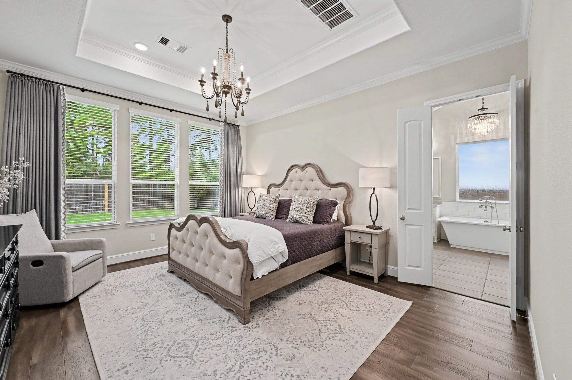 Primary suite with tray ceiling and statement chandelier from Arhaus