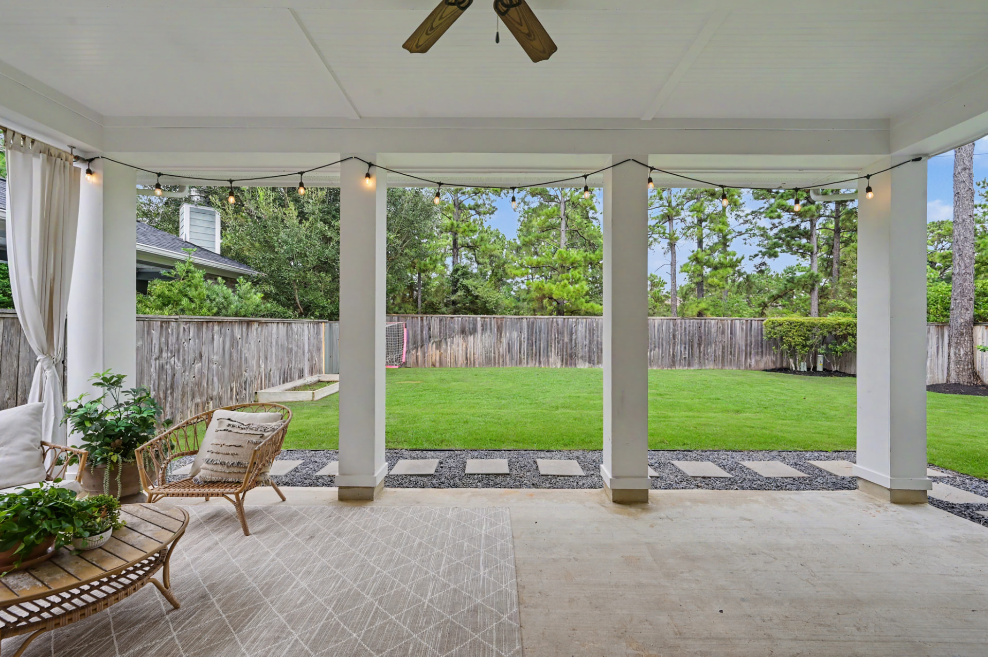 Covered Texas sized patio with ceiling fan and string lights